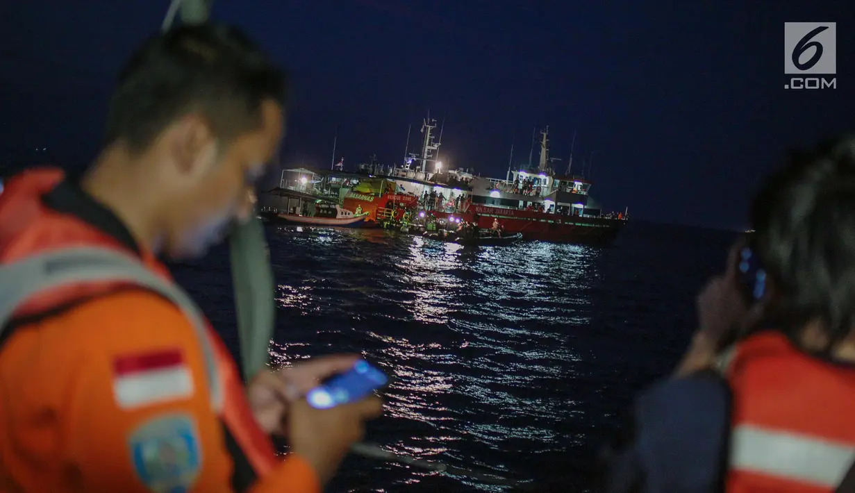 Anggota Basarnas menelepon saat mencari puing serta korban pesawat Lion Air JT 610 di perairan Karawang, Jawa Barat, Senin (29/10). Lion Air JT 610 hilang kontak usai lepas landas dari Bandara Soetta saat menuju Pangkalpinang. (Liputan6.com/Faizal Fanani)