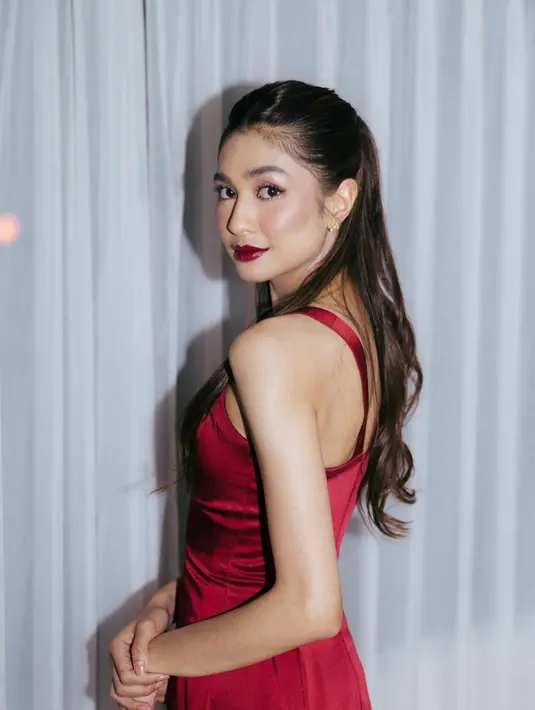 Di malam hari, Mikha kenakan dress satin bertali warna merah yang lebih bright. Lagi-lagi dengan dress polos tanpa aksen. [@miktambayong]
