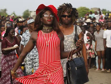 Sejumlah pria berpakaian wanita saat mengambil bagian dari parade Popo (topeng) dalam karnaval Bonoua , di timur Abidjan, Pantai Gading, (9/4). (REUTERS / Luc Gnago)
