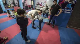 Pengungsi Suriah Amir al-Awad (kaos putih) memprakterkan gerakan kepada siswanya di Akademi Olahraga Suriah di Alexandria, Mesir (4/1). Akademi ini dibangun sejak 2016 dan pendirinya seorang pengungsi Suriah. (AFP/Khaled Desouki)