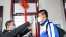 Seorang staf memeriksa suhu tubuh seorang murid di Sekolah Menengah Pertama No. 87 di Changchun, Provinsi Jilin, China timur laut, (20/4/2020). Lebih dari 56.000 pelajar tahun akhir sekolah menengah pertama di Changchun kembali masuk sekolah pada Senin (20/4). (Xinhua/Yan Linyun)