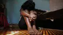 Seorang gadis remaja yang menjadi pekerja seks setelah sekolah di Kenya ditutup, duduk di sebuah kamar sewaan, di Nairobi, 1 Oktober 2020. Mereka melihat sumber pendapatan ibu mereka lenyap ketika pemerintah Kenya melakukan tindakan keras untuk mencegah penyebaran COVID-19. (AP Photo/Brian Inganga)