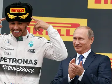 Presiden Russia, Vladimir Putin melihat pembalap F1 tim Mercedes, Lewis Hamilton merayakan kemenangannya di atas podium usai menjadi juara ajang balap GP Formula 1 Rusia di Sochi, Minggu (11/10/2015). (REUTERS/Grigory Dukor)