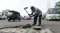 Aksi Dadarao Bilhore menutup lubang di jalanan Kota Mumbai India (AFP)