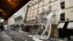 Pekerja melihat kerusakan yang terjadi usai penyangga proyek bangunan ambruk terkena angin kencang di Paris, Prancis (3/1). Tidak ada korban jiwa akibat jatuhnya penyangga proyek ini. (AFP Photo/Stephane De Sakutin)
