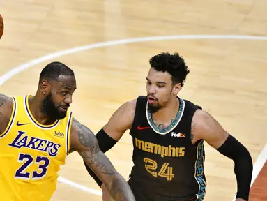 Pebasket Los Angeles Lakers, LeBron James, berusaha melewati pebasket Memphis Grizzlies, Dillon Brooks, pada laga NBA, Rabu (6/1/2021). LA Lakers menang tipis 94-92 atas Grizzlies. (AP Photo/Brandon Dill)