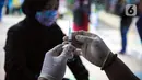 Paramedis Puskeswan DKP3 Jakarta Selatan menyiapkan vaksin antirabies untuk disuntikkan kepada hewan peliharaan saat pelaksanaan vaksinasi secara gratis di kawasan Tebet, Jakarta, Selasa (16/11/2021). Vaksinasi juga dilakukan agar Provinsi DKI Jakarta bebas rabies. (Liputan6.com/Faizal Fanani)