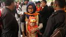 Orang tua dan bayi melewati pemeriksaan sebelum menonton laga Piala AFC 2018 antara Persija Jakarta vs Song Lam Nghe An di Stadion Utama GBK, Rabu (14/3/2018). Panpel menjual sekitar 65.000 lembar tiket. (Bola.com/Surya Bima Mahendarta)