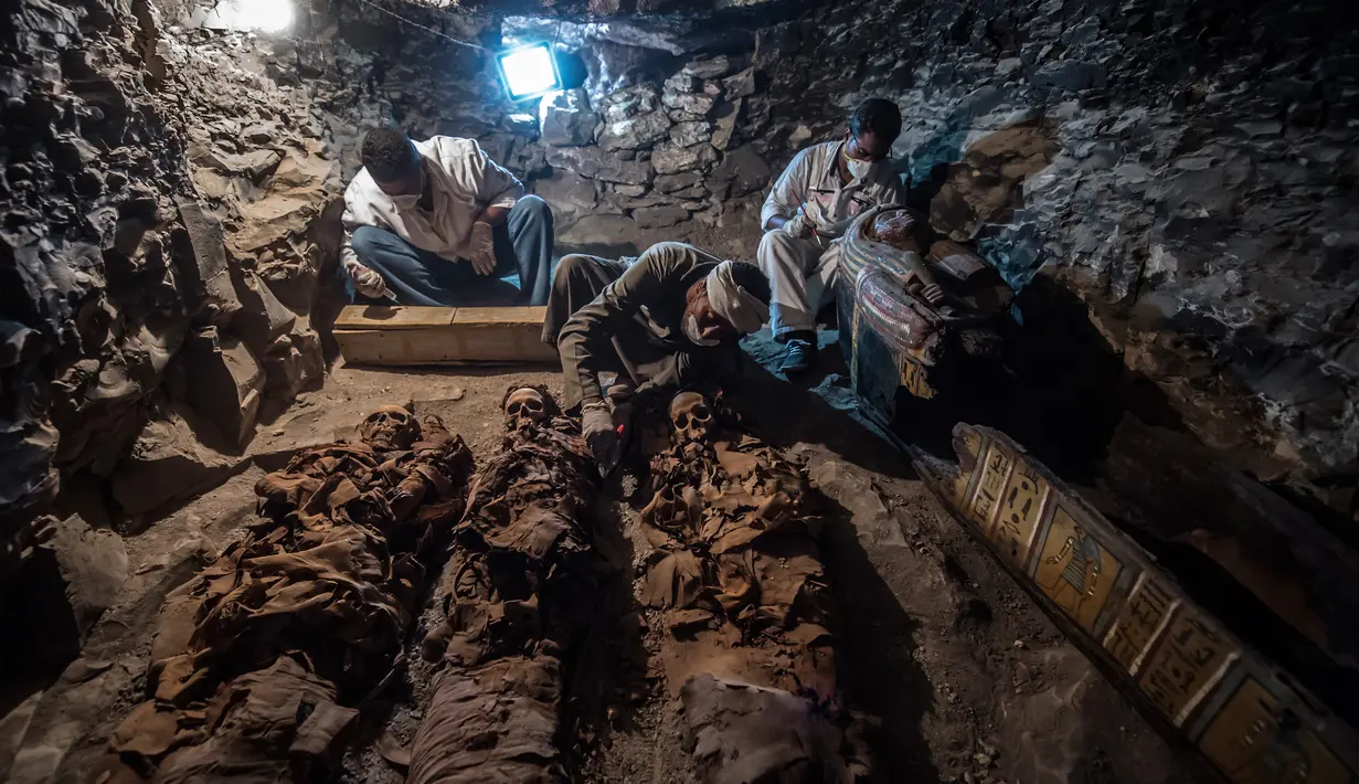 Arkeolog meneliti mumi yang berada di sebuah makam kuno di kota Luxor, Mesir (9/9). Mumi-mumi kuno ini diperkirakan berumur 3.500 tahun. (AFP Photo/Khaled Desouki)