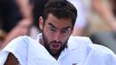 Mimik wajah Marin Cilic saat menggunakan handuk pada perempat final melawan Gilles Muller di The All England Lawn Tennis Club, London, (11/7/2017). (AFP/Glyn Kirk)