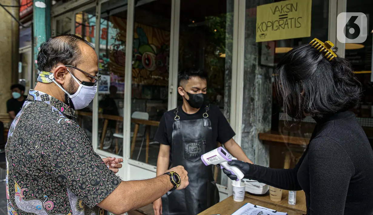 Warga diukur suhu tubuh sebelum menerima kopi gratis di Filosofi Kopi Melawai, Jakarta, Rabu (30/6/2021). Filosofi Kopi memberikan kopi gratis bagi warga yang telah melakukan vaksinasi COVID-19.. (Liputan6.com/Faizal Fanani)