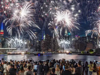 Penonton berkumpul di sepanjang tepi pantai Williamsburg untuk menyaksikan pertunjukan kembang api Macy pada perayaan Hari Kemerdekaan di Brooklyn, New York, Amerika Serikat, 4 Juli 2022. Kembang api meledak dari tongkang di East River. (AP Photo/Bebeto Matthews)