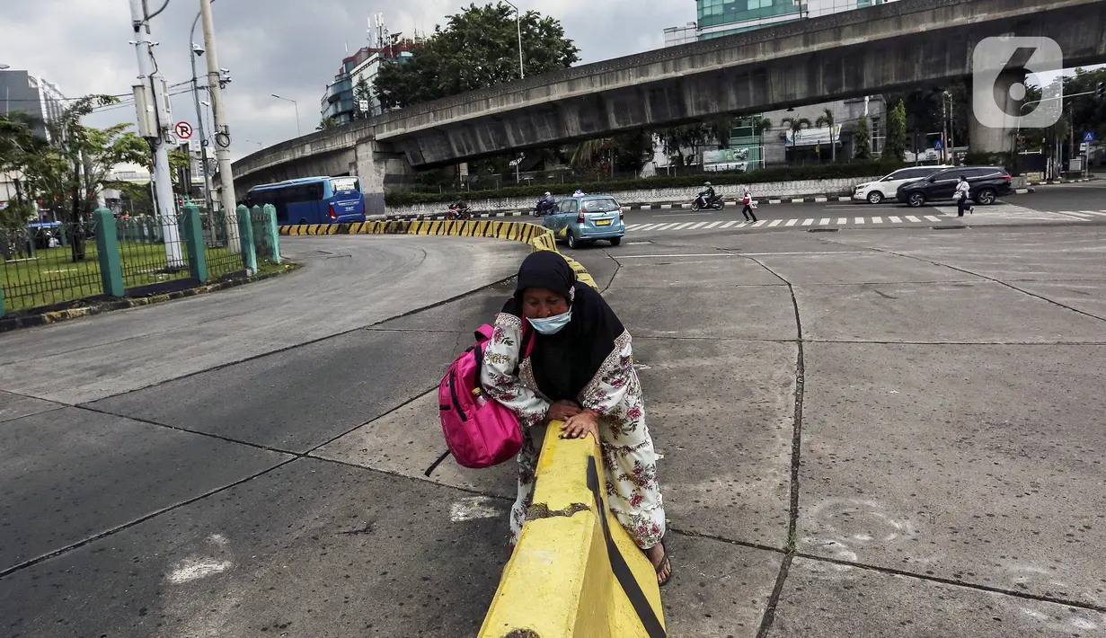 Warga melewati pembatas jalan di kawasan Blok-M, Jakarta, Senin (14/3/2022). Menurut Jubir Pemerintah untuk Penanganan COVID-19 Reisa Broto Asmoro, peralihan pandemi ke endemi tak bisa lepas dari jumlah kasus harian dan angka kematian rendah serta tingkat keterisian RS. (Liputan6.com/Johan Tallo)