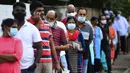 Para pemilih mengenakan masker saat antre di luar tempat pemungutan suara di Kolombo, Sri Lanka, Rabu (5/8/2020). Sri Lanka menggelar pemilihan parlemen di tengah pandemi COVID-19. (Ishara S. KODIKARA/AFP)