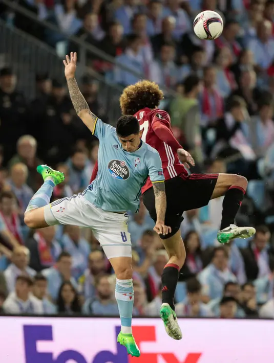 Gelandang Celta Vigo, Pablo Hernandez (kiri) berebut bola udara dengan gelandang MU, Marouane Fellaini pada pertandingan leg pertama semifinal Liga Europa di stadion Balaidos, Spanyol (5/5). MU menang 1-0 atas Celta Vigo. (AP Photo/Lalo R. Villar)