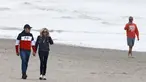 Presiden Prancis Emmanuel Macron dan istrinya Brigitte Macron berjalan di sepanjang pantai di Le Touquet, menjelang putaran kedua pemilihan presiden Prancis, Sabtu (23/4/2022). Emmanuel Macron akan menghadapi Marine Le Pen dalam putaran kedua pemilihan presiden (pilpres) pada 24 April 2022. (Ludovic MARIN / AFP)