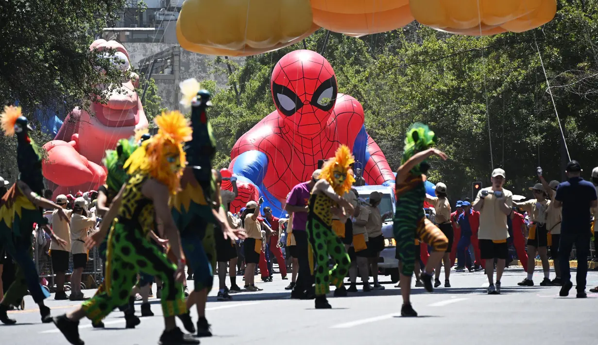 Para pengunjung tampil di depan balon Spiderman di Alameda Avenue, Santiago, Chile pada 1 Desember 2024. (RODRIGO ARANGUA/AFP)