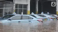 Kondisi taksi saat terendam banjir di Pool Blue Bird, Kramat Jati, Jakarta Timur, Rabu (1/1/2020). Akibat banjir setinggi hingga leher orang dewasa tersebut pool berhenti operasi dan sopir terpaksa diliburkan hingga waktu yang belum ditentukan. (merdeka.com/Iqbal S. Nugroho)