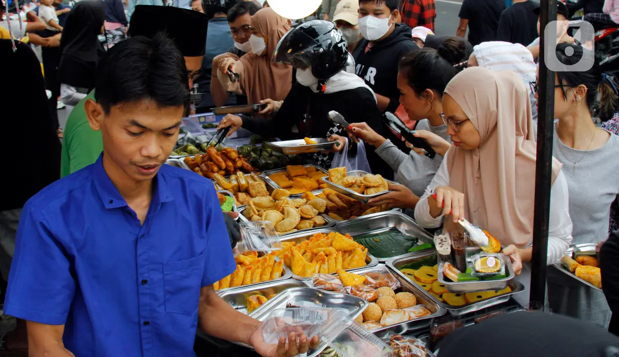 Pedagang melayani pembeli takjil menjelang waktu berbuka puasa di sepanjang Jalan Panjang, Kebon Jeruk, Jakarta, Selasa (4/4/2023). (Liputan6.com/Johan Tallo)