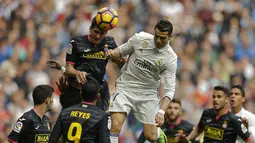 Cristiano Ronaldo berusaha menyundul bola saat dihadang pemain Espanyol pada lanjutan La Liga di Santiago Bernabeu stadium. Madrid, (18/2/2017). Real Madrid menang 2-0. (AP/Francisco Seco)