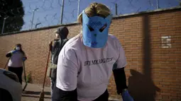 Seorang wanita memakai topeng sambil membersihkan jalanan kota madrid, Spanyol , Rabu  (14/10/2015).  Hal ini merupakan sikap protes terhadap pandangan masyrakat terhadap para PSK ini. . (REUTERS/Andrea Comas)