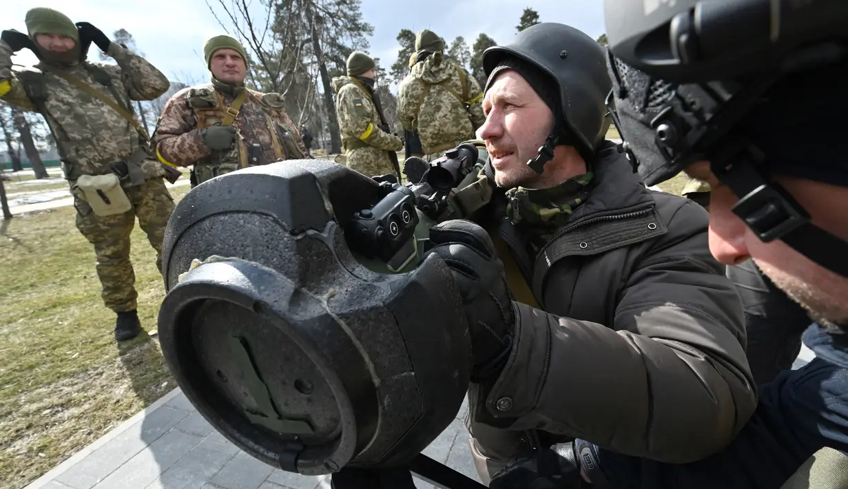 Anggota Pasukan Pertahanan Teritorial Ukraina memeriksa persenjataan baru, termasuk sistem anti-tank NLAW dan peluncur granat anti-tank portabel lainnya, di tengah invasi Rusia yang sedang berlangsung ke Ukraina di Kiev (9/3/2022). (AFP/Genya Savilov)