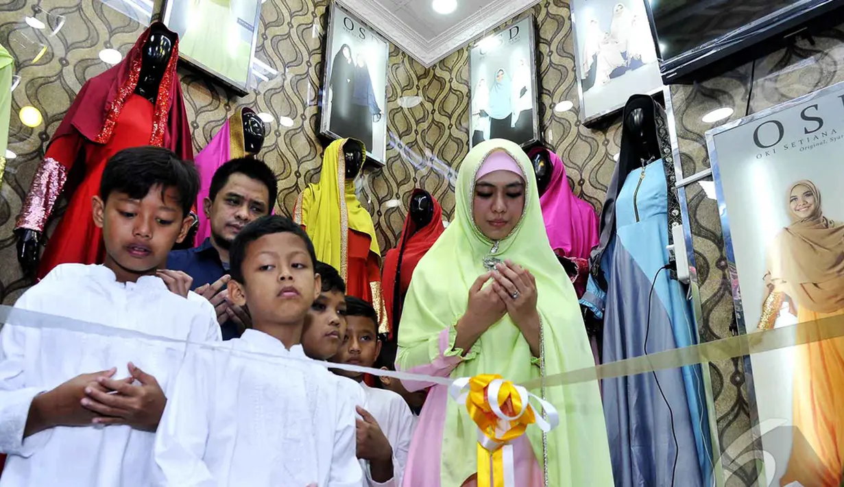 Oki Setiana Dewi dan suami bersama anak panti asuhan berdoa bersama sebelum meresmikan gerai busana muslimnya yang diberi brand OSD di Thamrin City, Jakarta, Selasa (13/1/2015). (Liputan6.com/Faisal R Syam)