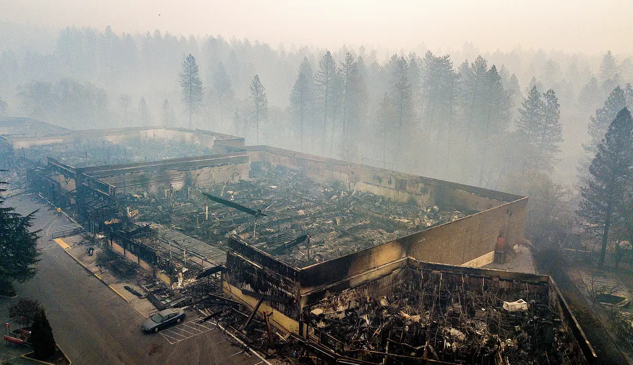 Asap mengepul usai kebakaran menghanguskan Old Town Plaza di Kota Paradise, California, AS, Kamis (15/11). Kebakaran telah menewaskan 48 orang dan lebih dari 100 lainnya masih belum ditemukan. (AP Photo/Noah Berger)