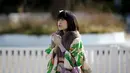 Seorang gadis Jepang berpakaian kimono berdoa saat perayaan Coming of Age Day (Hari Kedewasaan Nasional) di taman hiburan di Tokyo, Senin (11/1). Hari Kedewasaan Nasional ini dirayakan para muda-mudi yang menginjak usia 20 tahun. (REUTERS/Yuya Shino)