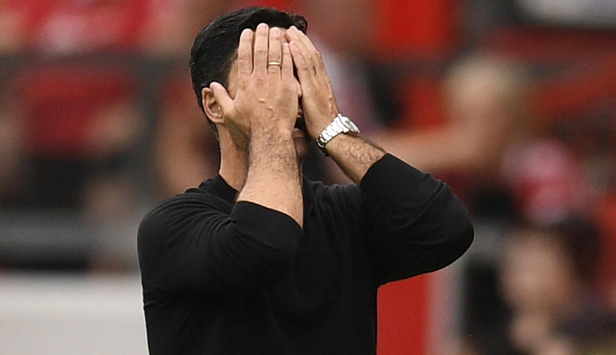 Ekspresi pelatih Arsenal, Mikel Arteta yang menutup wajahnya sebagai reaksi dari kekalahan timnya saat bertandang ke Markas Manchester United dalam pertandingan pekan keenam Liga Inggris 2022/2023. (AFP/Oli Scarff)