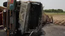 Bangkai truk tangki minyak yang hangus terbakar usai terbalik dan meledak di jalan raya dekat Bahawalpur, Pakistan (25/6). Dikabarkan, sedikitnya 123 orang tewas dan 100 lainnya mengalami luka-luka. (AFP Photo/SS Mirza)