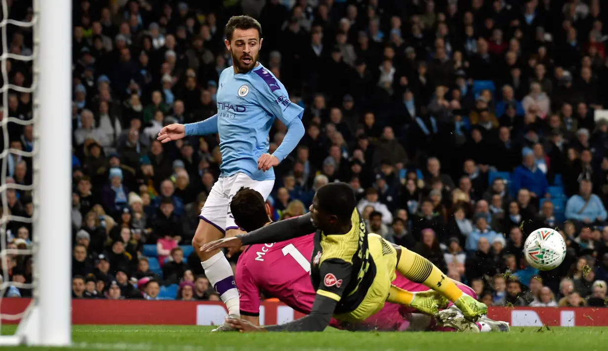 Gelandang Manchester City, Bernardo Silva, berusaha mencetak gol melewati kiper Southampton Alex McCarthy dan rekannya,  Kevin Danso pada babak ketiga  Carabao Cup 2019/2020 di Stadion Etihad, Selasa (29/10/2019). Manchester City mengalahkan Southampton 3-1 d. (AP/Rui Vieira)