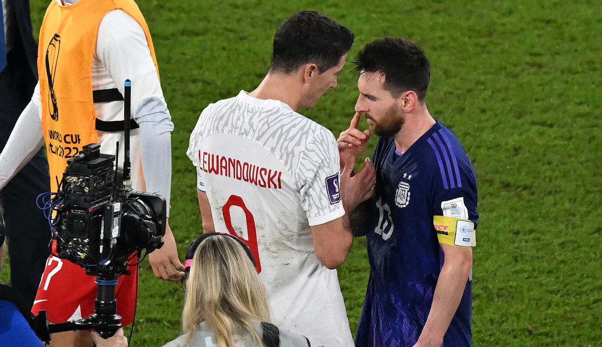 Dalam laga sebelumnya, tepatnya pada matchday pamungkas Grup C saat Polandia kalah 0-2 dari Argentina (1/12/2022), Robert Lewandowski juga kedapatan berbisik dengan Lionel Messi yang notabene juga merupakan pemain yang kini membela PSG. (AFP/Glyn Kirk)