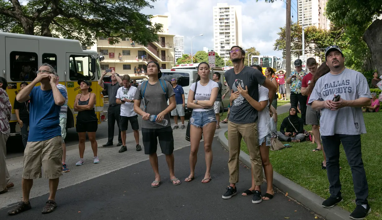 Warga sekitar menyaksikan kebakaran yang melanda apartemen Marco Polo, Honolulu (14/7). Menurut petugas setempat, titik api pertama kali muncul di lantai 26 hingga akhirnya meluas dan menjalar ke beberapa bagian gedung. (AP Photo/Marco Garcia)