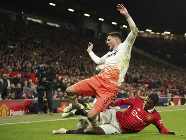 Bek Manchester United atau MU Tyrell Malacia berebut bola dengan gelandang West Ham United Pablo Fornals pada putaran kelima Piala FA di Old Trafford, Kamis (2/3/2023) dinihari WIB. MU berhasil lolos ke babak perempat final Piala FA. (AP Photo/Dave Thompson)