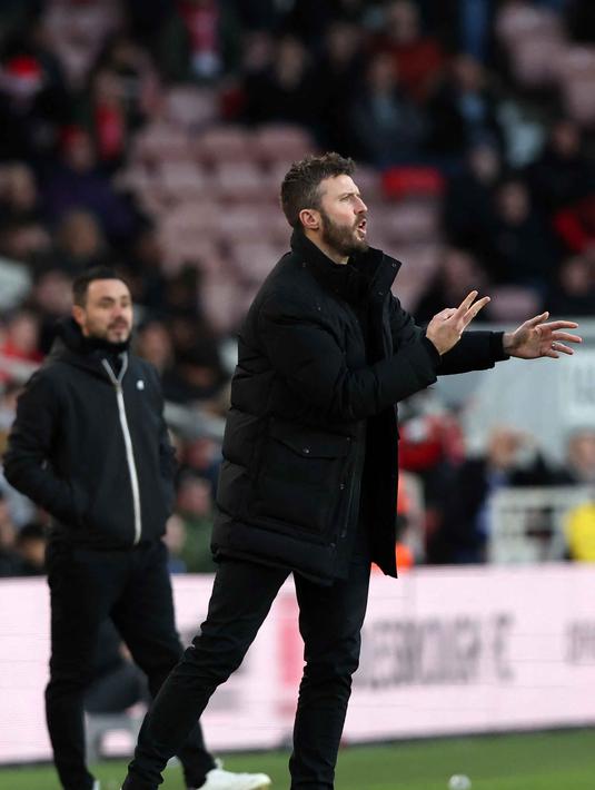 Bersama MU, sejumlah gelar berhasil ia raih, di antaranya lima gelar Liga Inggris, juara Liga Champions, juara Piala FA, dua kali juara Piala Liga Inggris, Liga Europa, dan Piala Dunia Antarklub. Tampak dalam foto, Michael Carrick saat masih menjadi pelatih Middlesbrough memberi isyarat di pinggir lapangan selama pertandingan sepak bola putaran ketiga Piala FA Inggris antara Middlesbrough dan Brighton and Hove Albion di Stadion Riverside di Middlesbrough, timur laut Inggris pada 7 Januari 2023. (Nigel Roddis/AFP)