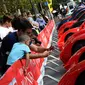 Pengunjung mengambil gambar mobil Ferrari yang dipamerkan saat perayaan ulang tahun Ferrari ke-70 di Corso Sempione di Milan, Italia (8/9). Dalam acara ini sekitar 500 mobil Ferrari dari berbagai tipe pamerkan. (AFP Photo/Miguel Medina)