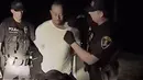 Dalam gambar yang diambil dari video terlihat pegolf ternama AS, Tiger Woods ditangkap dua polisi di Jupiter, Florida, 29 Mei 2017. Tiger Woods harus berurusan dengan pihak kepolisian karena menyetir dalam keadaan mabuk (HO/ Jupiter Police Department/AFP)