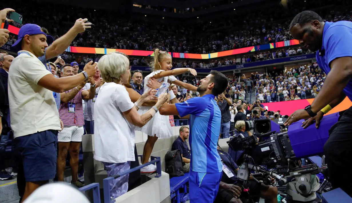 Petenis asal Serbia, Novak Djokovic (tengah), menghampiri putrinya, Tara, yang berada di tribun penonton setelah mengalahkan petenis asal Rusia Daniil Medvedev dalam partai final US Open 2023 yang berlangsung di Arthur Ashe, New York, Senin (11/9/2023) pagi WIB. (AFP/Kena Betancur)