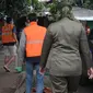 Anggota Satpol PP menghukum warga untuk menyapu jalan saat razia penggunaan masker di Kebon Nanas, Jakarta, Selasa (15/6/2021). Saat kasus positif Covid-19 di Jakarta meningkat, masih banyak warga yang belum menjalankan protokol kesehatan, salah satunya mengenakan masker. (merdeka.com/Imam Buhori)