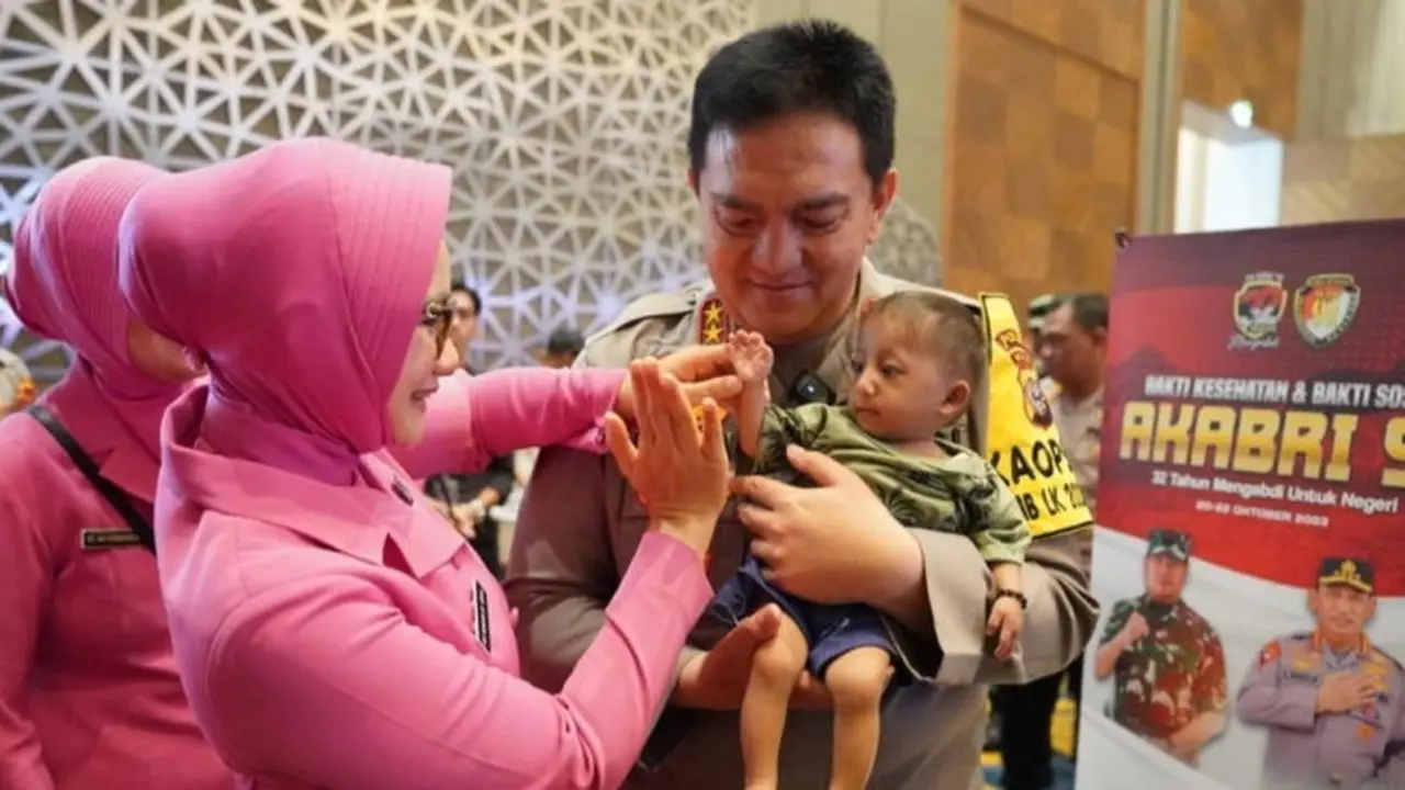Kapolda Riau Irjen Mohammad Iqbal menggendong anak yang mengikuti bakti kesehatan alumni Akabri 91 di Pekanbaru.
