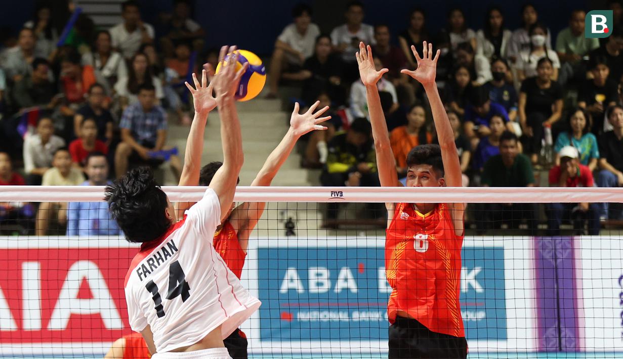 Pemain Timnas voli putra Indonesia, Halim Farhan (kiri), melakukan smash dan berusaha dihadang oleh pemain Vietnam pada laga Semifinal Bola Voli Putra SEA Games 2023 di Olympic Complex Indoor Main Hall, Phonm Penh, Minggu (7/5/2023). (Bola.com/Abdul Aziz)