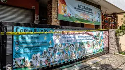 Gerbang pusat penitipan anak Little Aresha, disegel dengan garis polisi setelah adanya dugaan penganiayaan anak, di salah satu pusat penitipan, Yogyakarta pada Senin 27 April 2026. (DEVI RAHMAN/AFP)