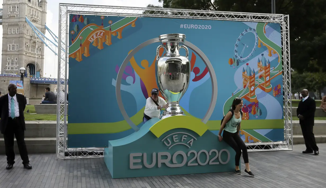 Warga berpose dengan logo Piala Eropa 2020 saat  peluncuran di London, Inggris, 21 September 2016. UEFA memundurkan jadwal Piala Eropa 2020 hingga tahun 2021. (AP Photo/Tim Ireland, File)