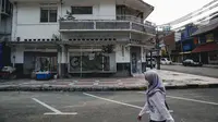 Warga berjalan di dekat pertokoan yang tutup di kawasan little Tokyo, Blok M, Jakarta, Rabu (21/7/2021). Pemerintah resmi menetapkan pemberlakuan pembatasan kegiatan masyarakat (PPKM) level 4 hingga 25 Juli mendatang untuk mencegah penyebaran virus Covid-19. (Liputan6.comn/Faizal Fanani)
