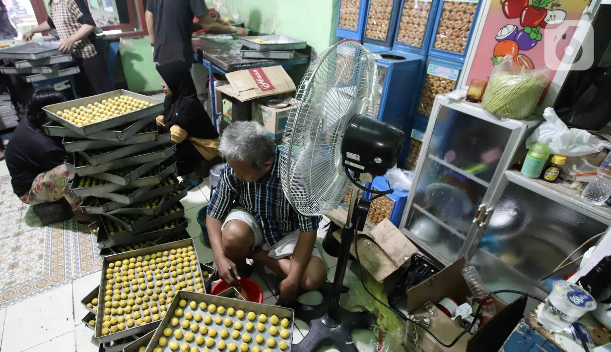Pekerja menyelesaikan pembuatan kue kering skala rumah tangga Pusaka Kwitang di kawasan Senen, Jakarta, Rabu (13/4/2022). Pedagang mengaku terpaksa menaikkan harga jual kue kering Ramadhan akibat tingginya harga bahan baku. (Liputan6.com/Herman Zakharia)