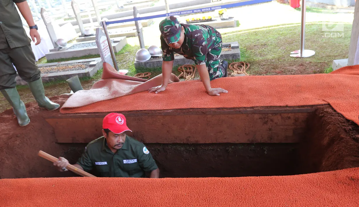 Pekerja menggali makam Presiden ke-3 RI BJ Habibie di TMP Kalibata, Jakarta, Kamis (12/9/2019). Habibie bakal dimakamkan di TMP Kalibata hari ini. (Liputan6.com/Herman Zakharia)