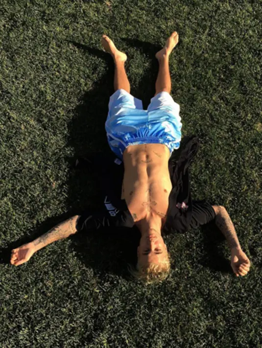 Berbagai pose Justin Bieber yang kerap memamerkan perut kotak-kotaknya, mantan kekasih Selena Gomez ini tampak santai berbaring di lapangan rumput. (via instagram/@justinbieber)