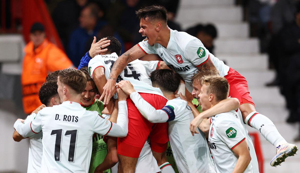 Para pemain FC Twente merayakan gol yang dicetak oleh Sam Lammers ke gawang Manchester United pada matchday 1 Liga Europa 2024/2025 di Old Trafford, Kamis (26/9/2024) dini hari WIB. (AFP/Darren Staples)