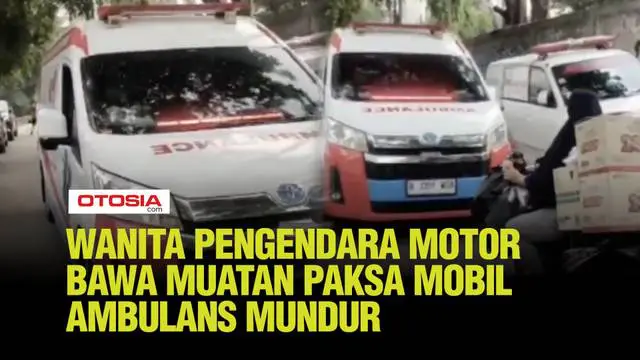Sebuah ambulans terlihat harus mundur karena di depannya ada seorang wanita pengendara motor yang membawa muatan banyak di belakang motornya.